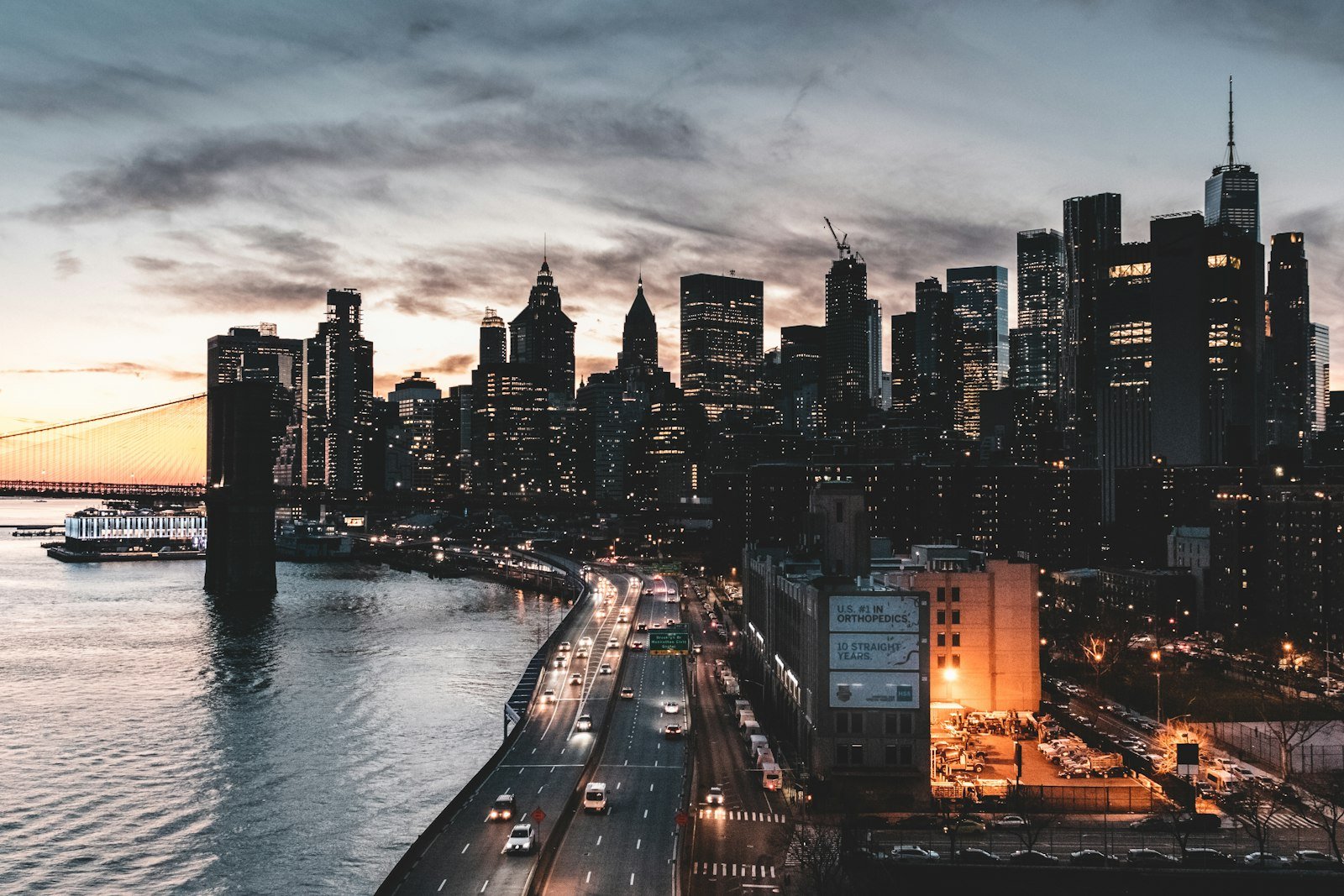 City buildings near the water during night time in New York City, USA
