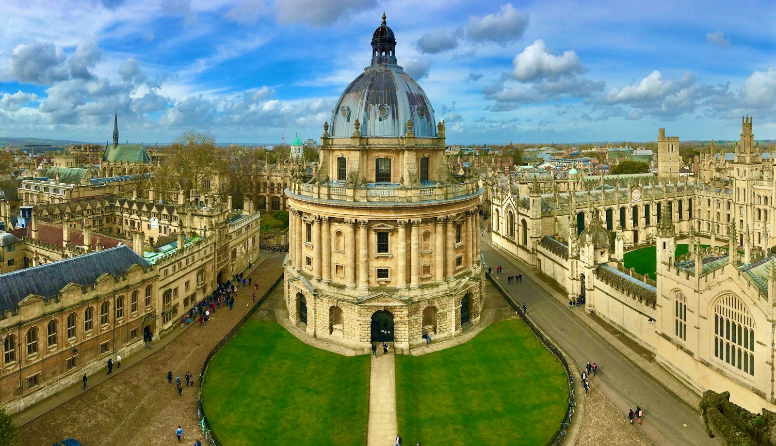 The Radcliffe Camera building surrounded by historic stone university colleges in Oxford, England